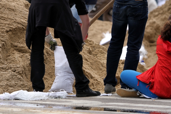 Hochwasser-Helfer beim Befüllen von Sandsäcken, über dts Nachrichtenagentur