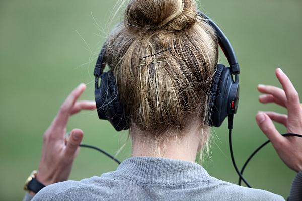 Frau mit Kopfhörern, via dts Nachrichtenagentur